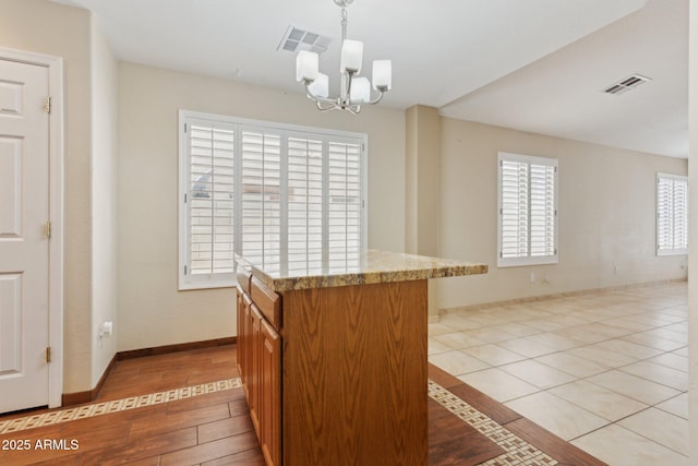 4718 E Woburn Ln, Cave Creek, AZ 85331 - kitchen with a chandelier, light countertops, light wood-style flooring, decorative light fixtures, and open floor plan