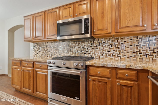 4718 E Woburn Ln, Cave Creek, AZ 85331 - kitchen with appliances with stainless steel finishes, tasteful backsplash, and brown cabinets