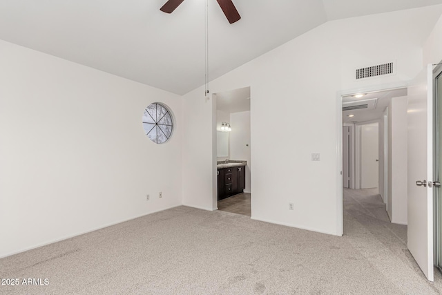 unfurnished bedroom featuring high vaulted ceiling, light colored carpet, ceiling fan, and ensuite bathroom