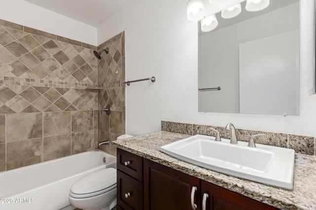 full bathroom featuring tiled shower / bath combo, vanity, and toilet