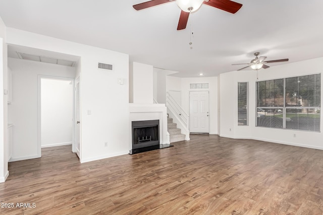 unfurnished living room featuring ceiling fan and hardwood / wood-style floors