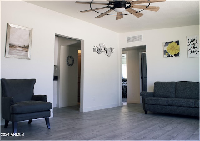 living area featuring hardwood / wood-style floors and ceiling fan