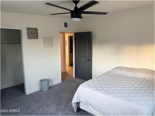 bedroom with dark colored carpet, ceiling fan, and a closet