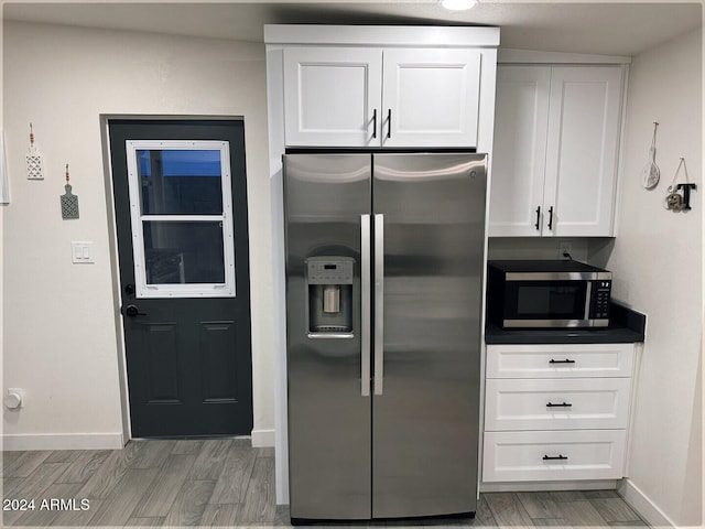 kitchen featuring white cabinetry, appliances with stainless steel finishes, and wood-type flooring