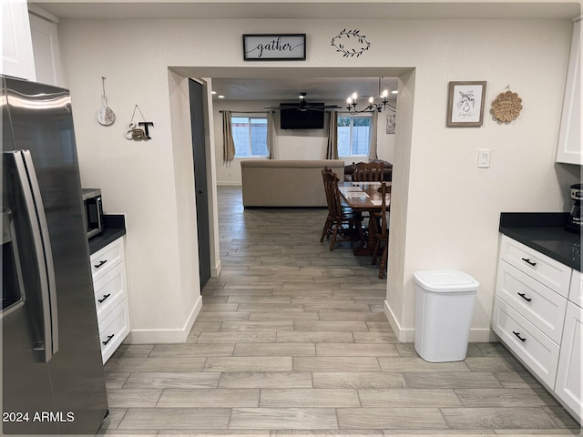 kitchen with white cabinetry, light wood-type flooring, and stainless steel appliances