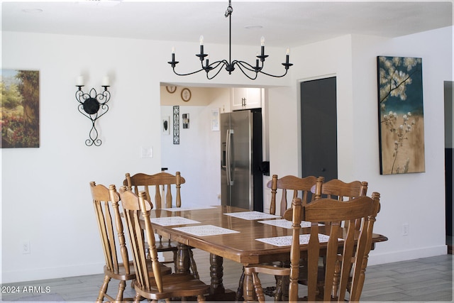 dining area featuring hardwood / wood-style flooring and a notable chandelier