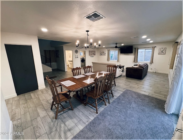 dining room featuring ceiling fan with notable chandelier, wood-type flooring, and washer / clothes dryer