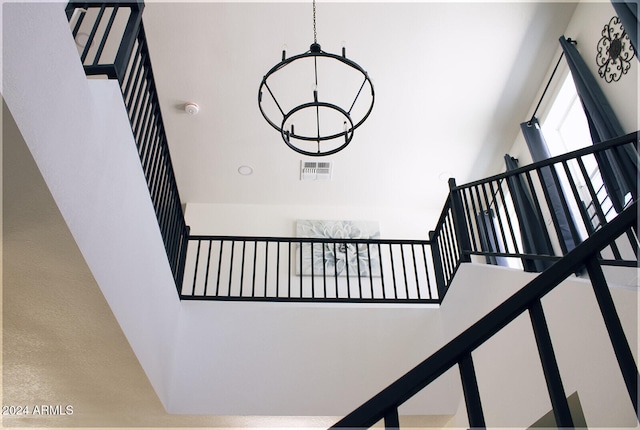 stairs featuring a chandelier and a high ceiling