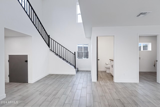 interior space featuring a high ceiling and light hardwood / wood-style flooring