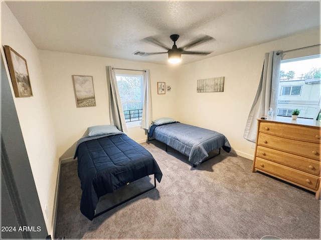 carpeted bedroom featuring a textured ceiling and ceiling fan