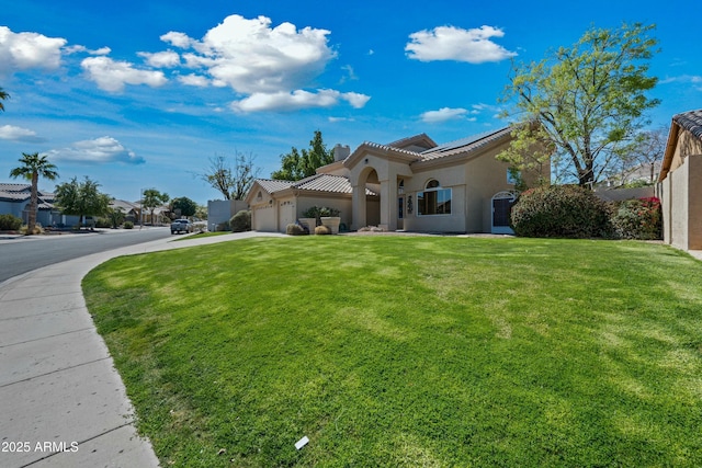 mediterranean / spanish-style house with an attached garage, a tile roof, driveway, stucco siding, and a front yard