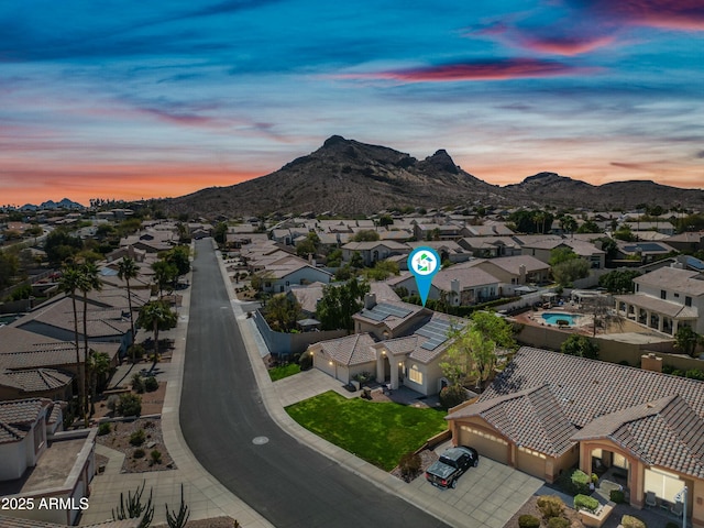 aerial view at dusk featuring a residential view and a mountain view