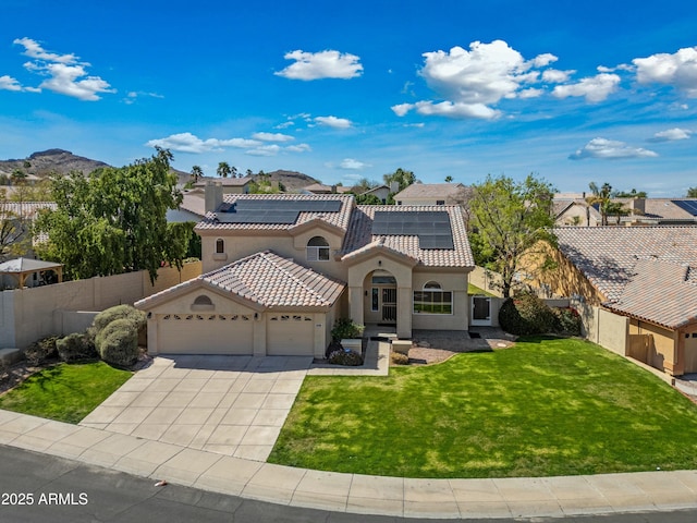 mediterranean / spanish-style home with a garage, fence, a tile roof, stucco siding, and a front lawn