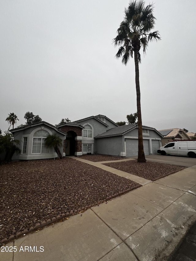 view of front of home with a garage, concrete driveway, and stucco siding