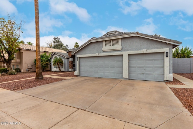 ranch-style house featuring concrete driveway, a tile roof, an attached garage, and stucco siding