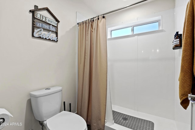 bathroom featuring a shower with shower curtain and toilet