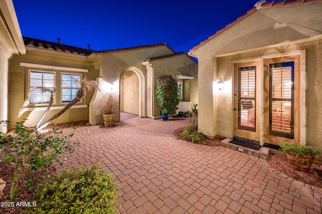 exterior entry at twilight with a patio