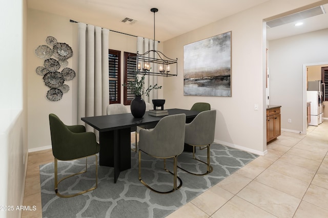 tiled dining area featuring a notable chandelier