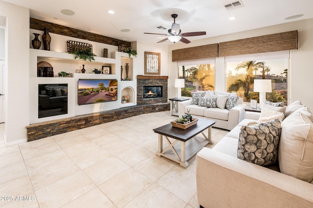 living room with ceiling fan, built in features, and a fireplace