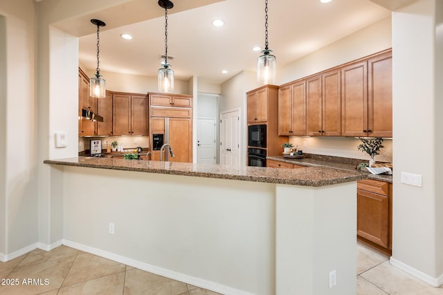 kitchen featuring kitchen peninsula, pendant lighting, dark stone countertops, and black appliances