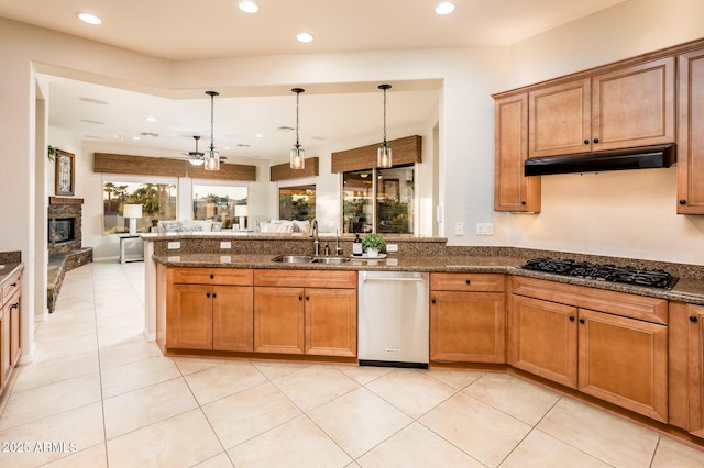 kitchen featuring a fireplace, sink, black gas cooktop, dishwasher, and hanging light fixtures