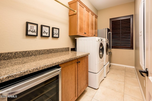 laundry area featuring wine cooler, washer and clothes dryer, and light tile patterned floors