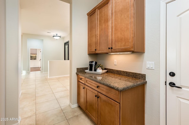 kitchen with dark stone countertops and light tile patterned floors