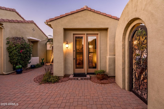 exterior entry at dusk with a patio area