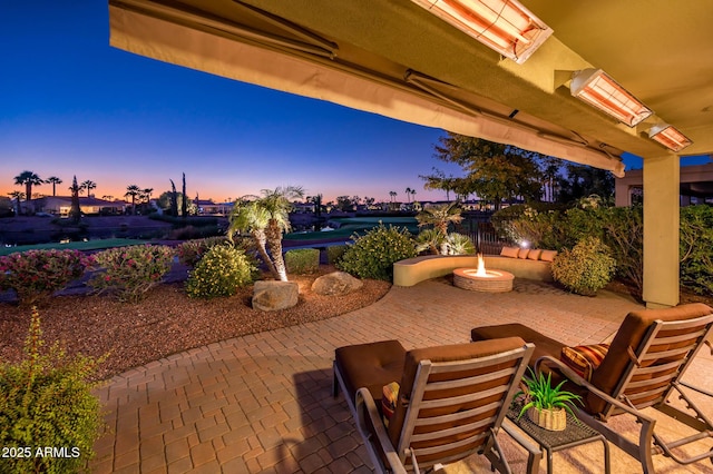 patio terrace at dusk featuring an outdoor fire pit