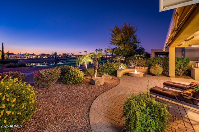 yard at dusk featuring a patio and an outdoor fire pit