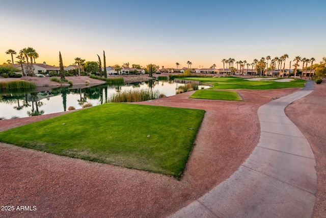 view of property's community with a water view and a lawn