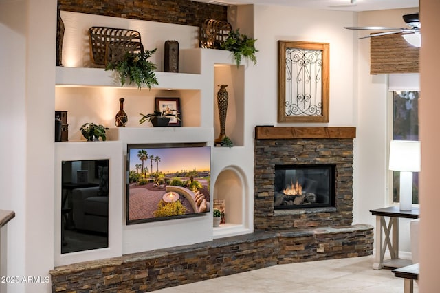 living room featuring ceiling fan and a fireplace