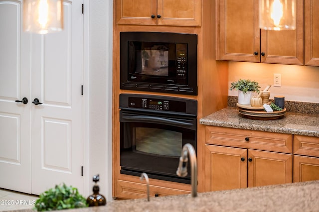 kitchen featuring light stone counters and black appliances