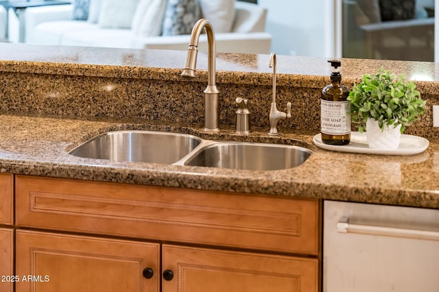 details with sink, stainless steel dishwasher, and stone countertops