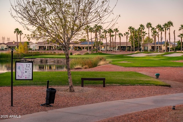 surrounding community with a lawn and a water view