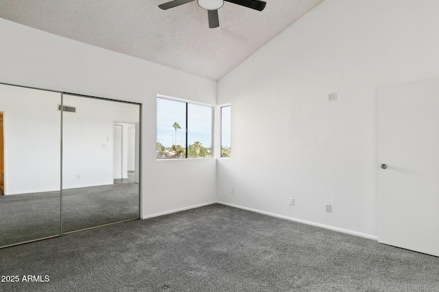 unfurnished bedroom with ceiling fan, dark carpet, lofted ceiling, and a closet