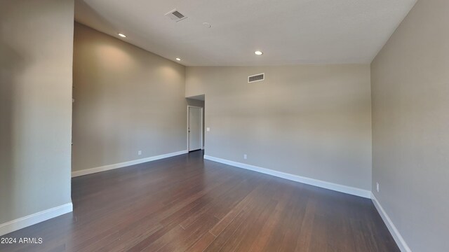 empty room with wood-type flooring and high vaulted ceiling