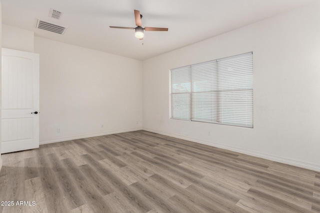 4571 N Arbor Way, Buckeye, AZ 85396 - unfurnished room with wood finished floors, a ceiling fan, and baseboards