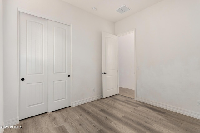 4571 N Arbor Way, Buckeye, AZ 85396 - unfurnished bedroom featuring wood finished floors, a closet, and baseboards