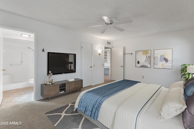 bedroom with ceiling fan, connected bathroom, carpet, and a textured ceiling