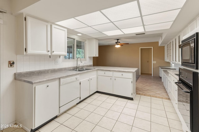 kitchen featuring white cabinets, black appliances, sink, kitchen peninsula, and light tile patterned floors