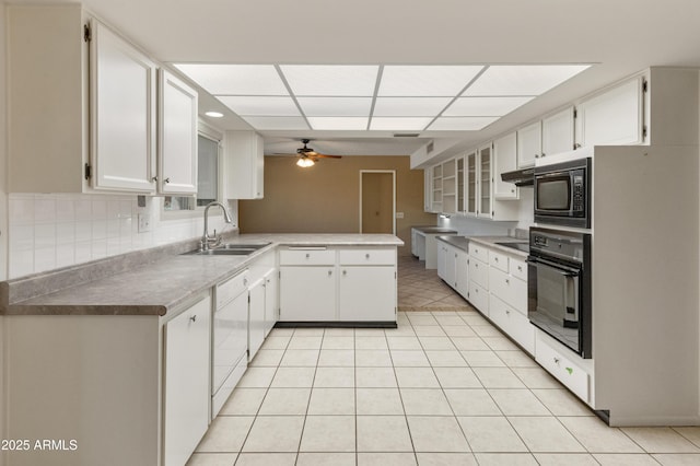 kitchen featuring dishwasher, black oven, white cabinetry, sink, and built in microwave