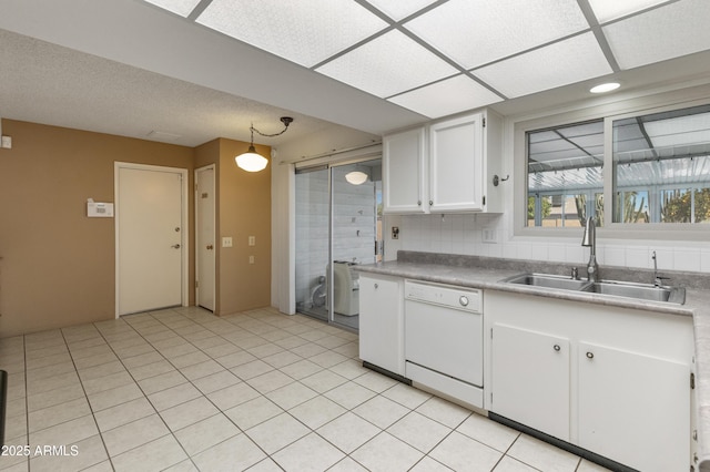 kitchen with white dishwasher, white cabinetry, hanging light fixtures, decorative backsplash, and sink