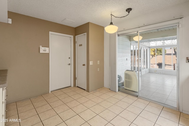 empty room featuring light tile patterned floors and a textured ceiling