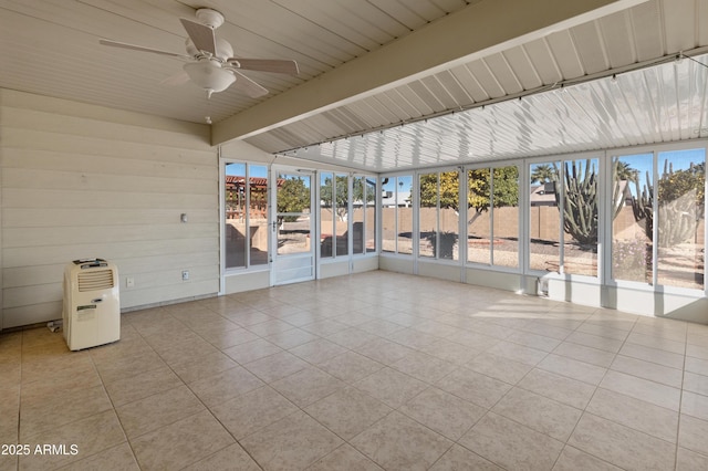 unfurnished sunroom featuring ceiling fan, lofted ceiling with beams, and a healthy amount of sunlight