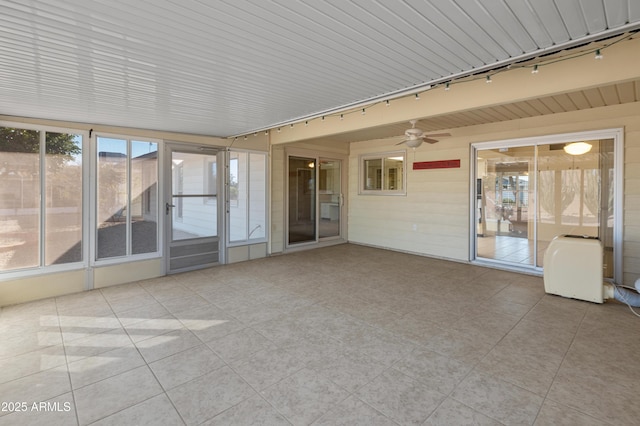 unfurnished sunroom with ceiling fan