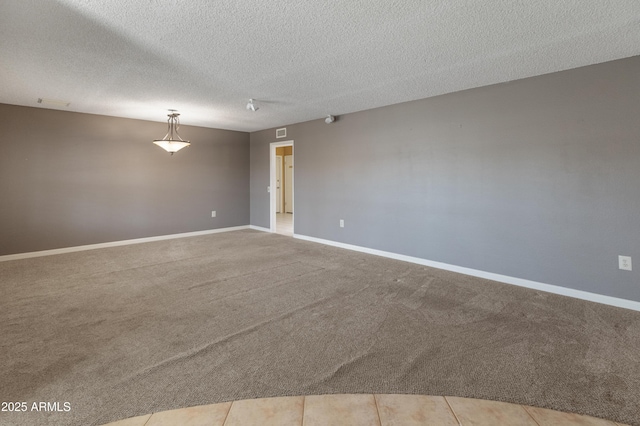 empty room featuring light tile patterned floors and a textured ceiling