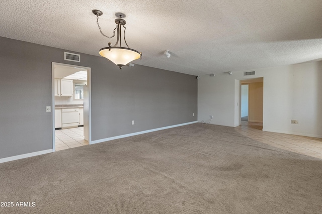 unfurnished room with light carpet and a textured ceiling