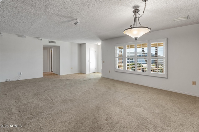 carpeted spare room with a textured ceiling