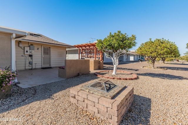 exterior space with an outdoor fire pit, a patio, and a pergola